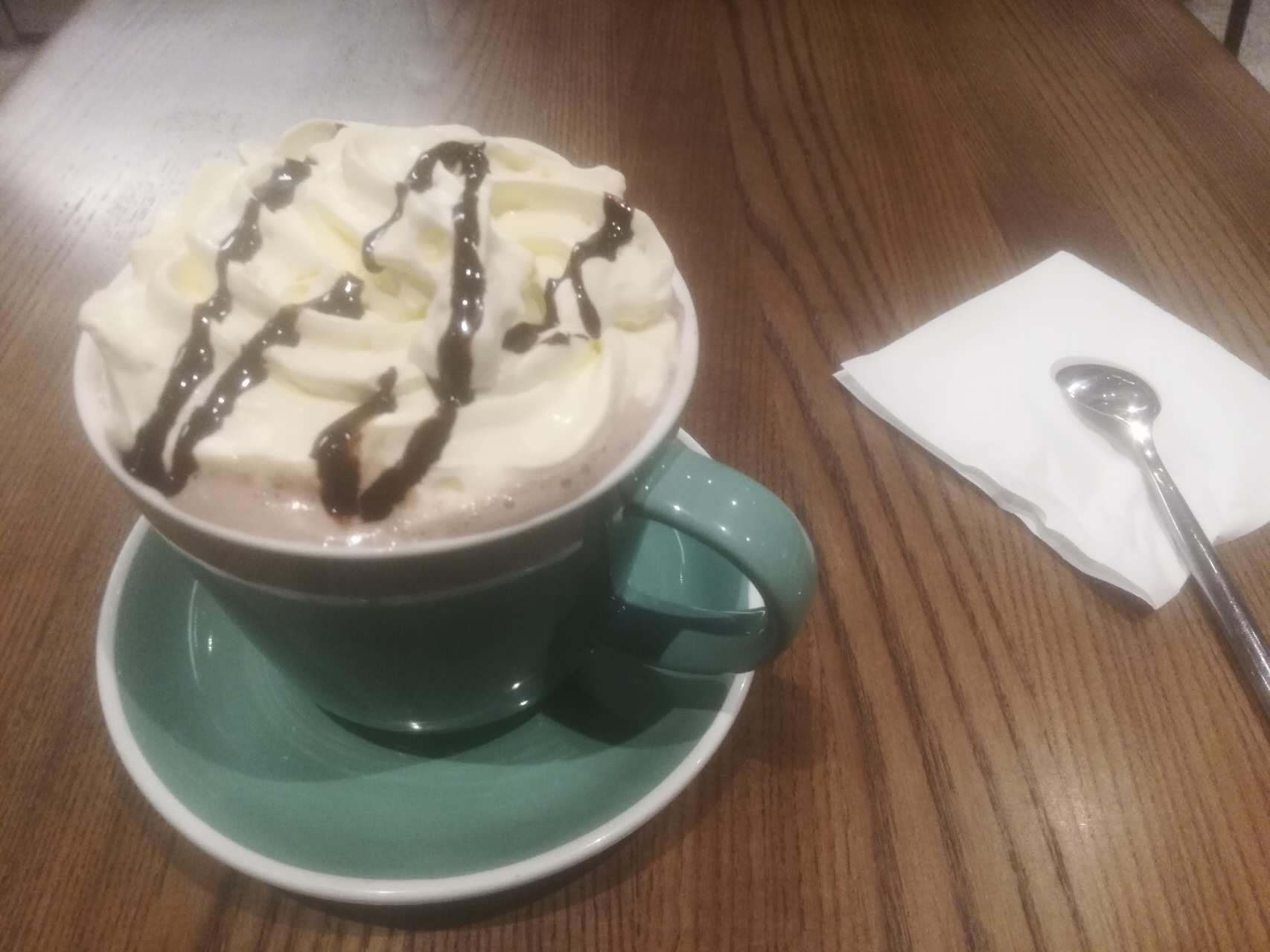 A drink topped with whipped cream and chocolate drizzle