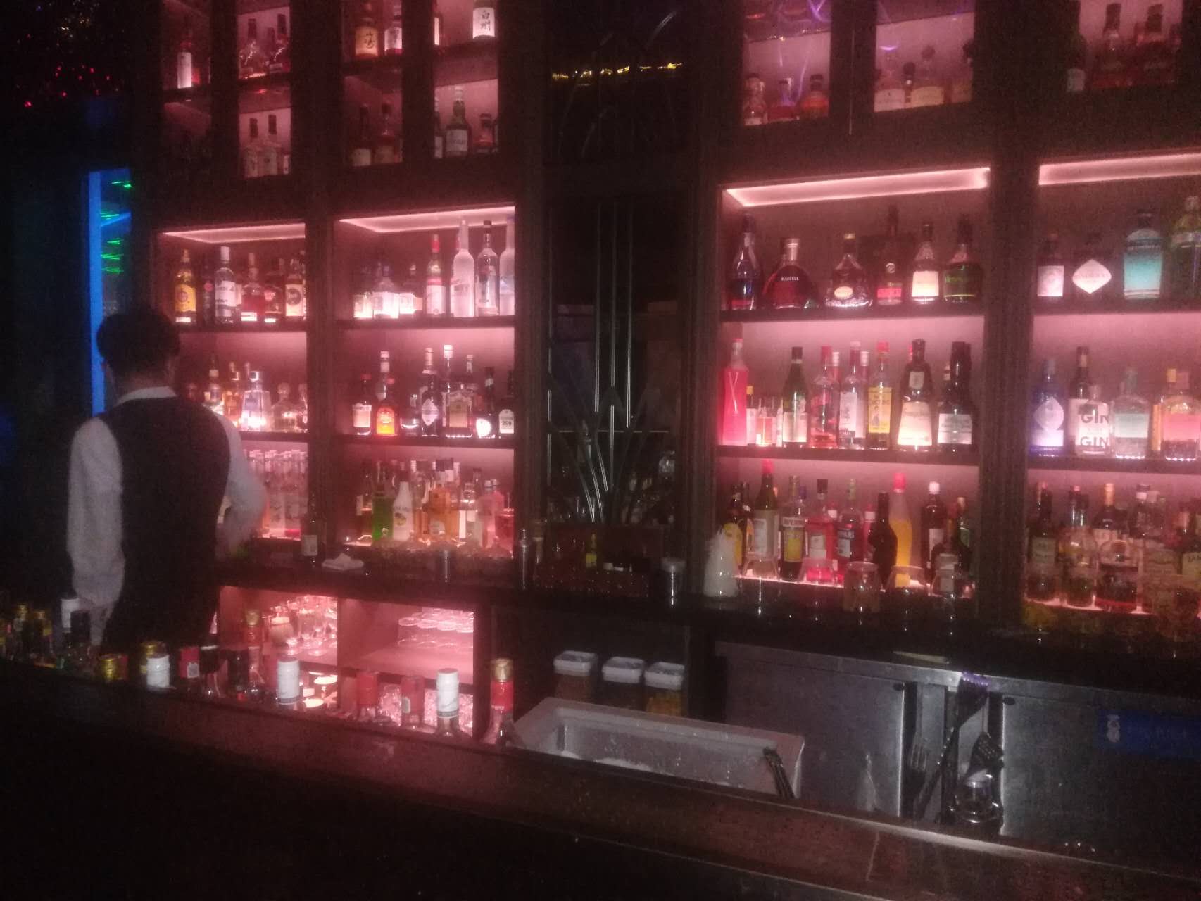 Illuminated bottles behind a bar